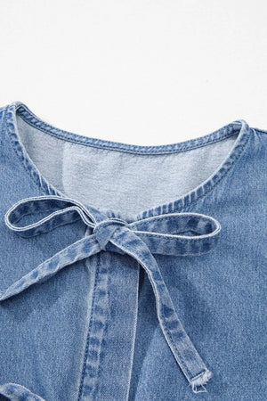 Denim peplum blouse in medium wash with a tie-neck detail