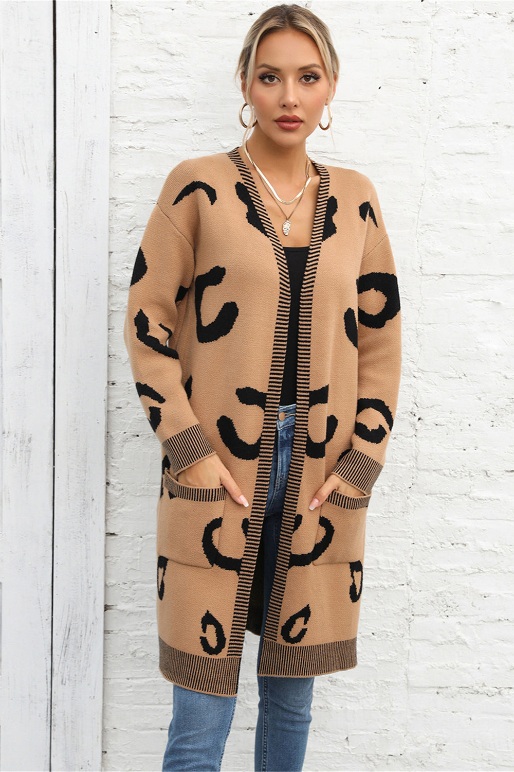 Khaki leopard print knit cardigan with black striped trim and pockets.