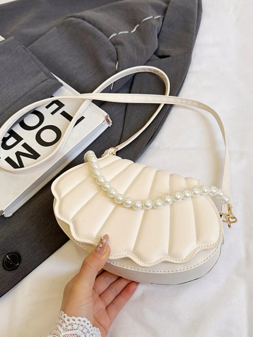 White shell crossbody bag with pearl embellishment and a white strap