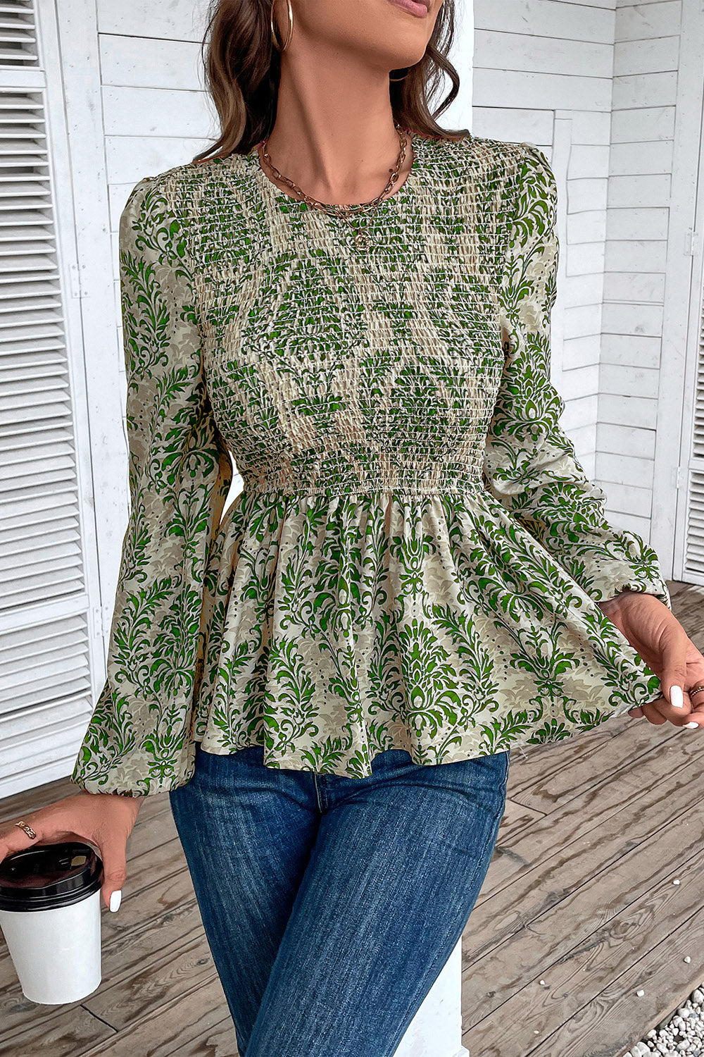 Green damask print peplum blouse with smocking and long sleeves.