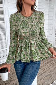 Green damask print peplum blouse with smocking and long sleeves.