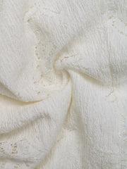 White lace camisole fabric with textured detail and open knit pattern.