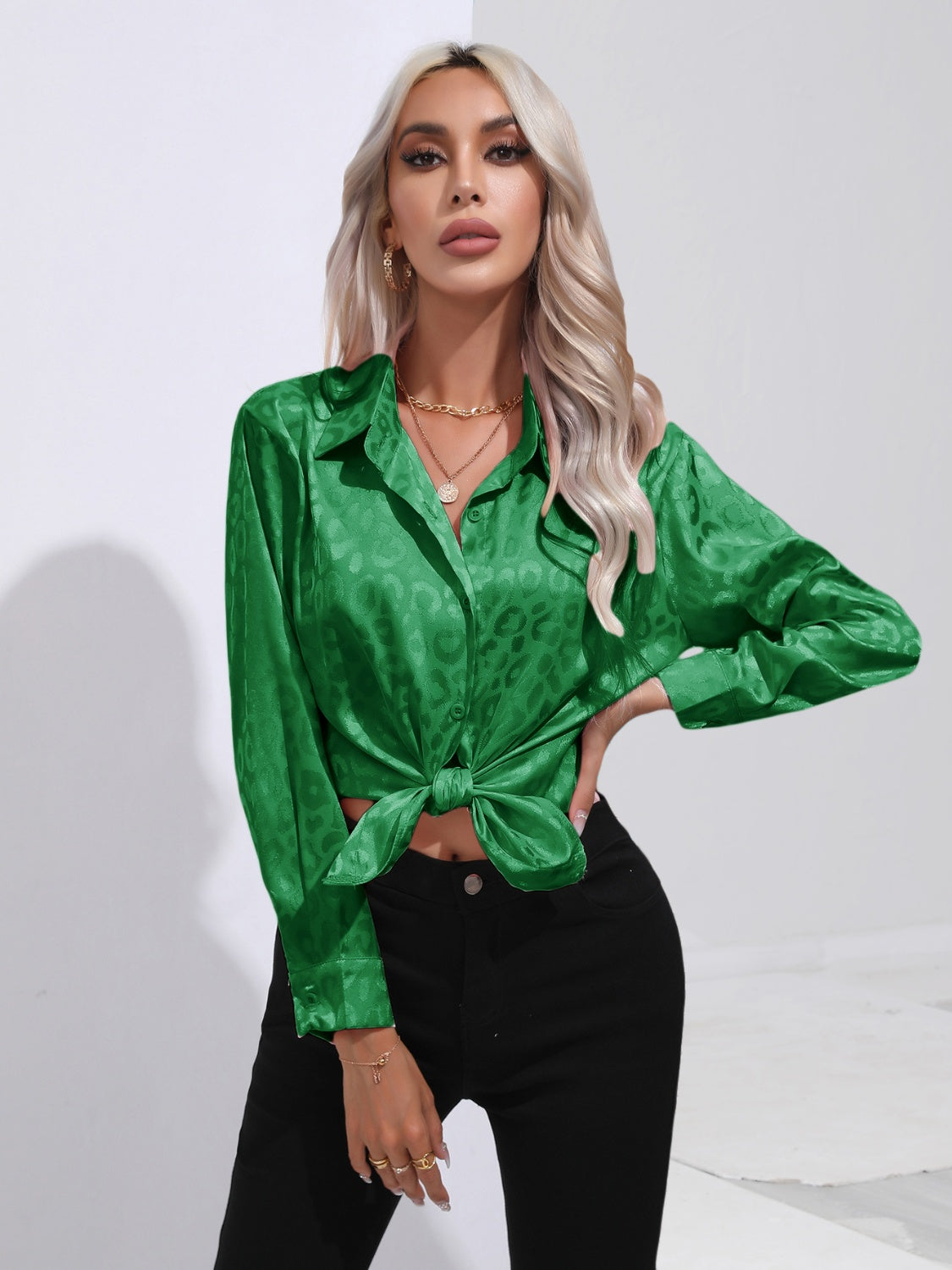 Green satin leopard print tie-front blouse with button-down front and long sleeves.