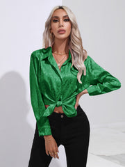 Green satin leopard print tie-front blouse with button-down front and long sleeves.
