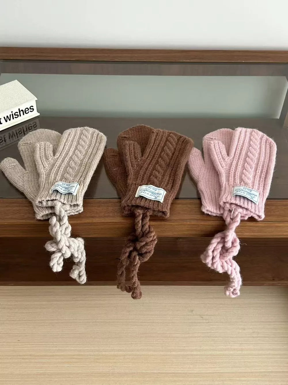 Cozy cable knit acrylic gloves in beige, brown, and pink with braided ties.