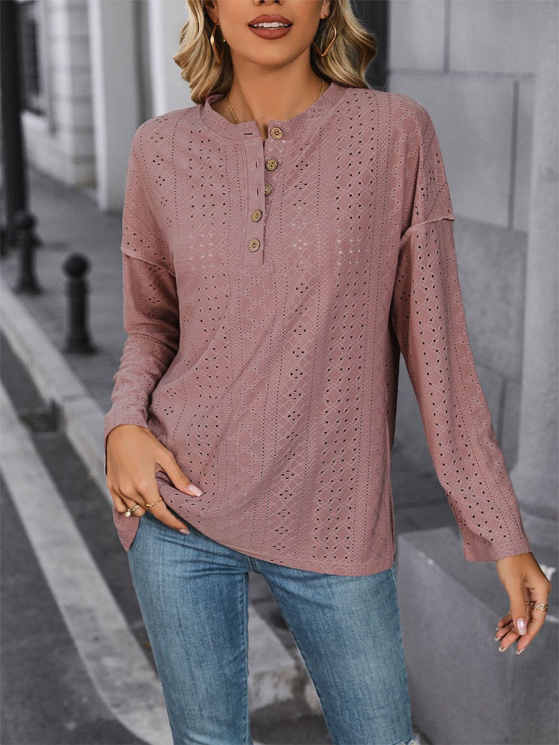 Dusty pink perforated henley shirt with button detail and slit hem.