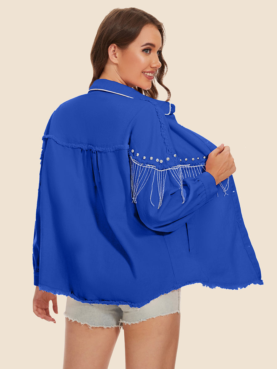 Royal blue trucker jacket with fringe and pearl embellishments on shoulders and frayed hem.