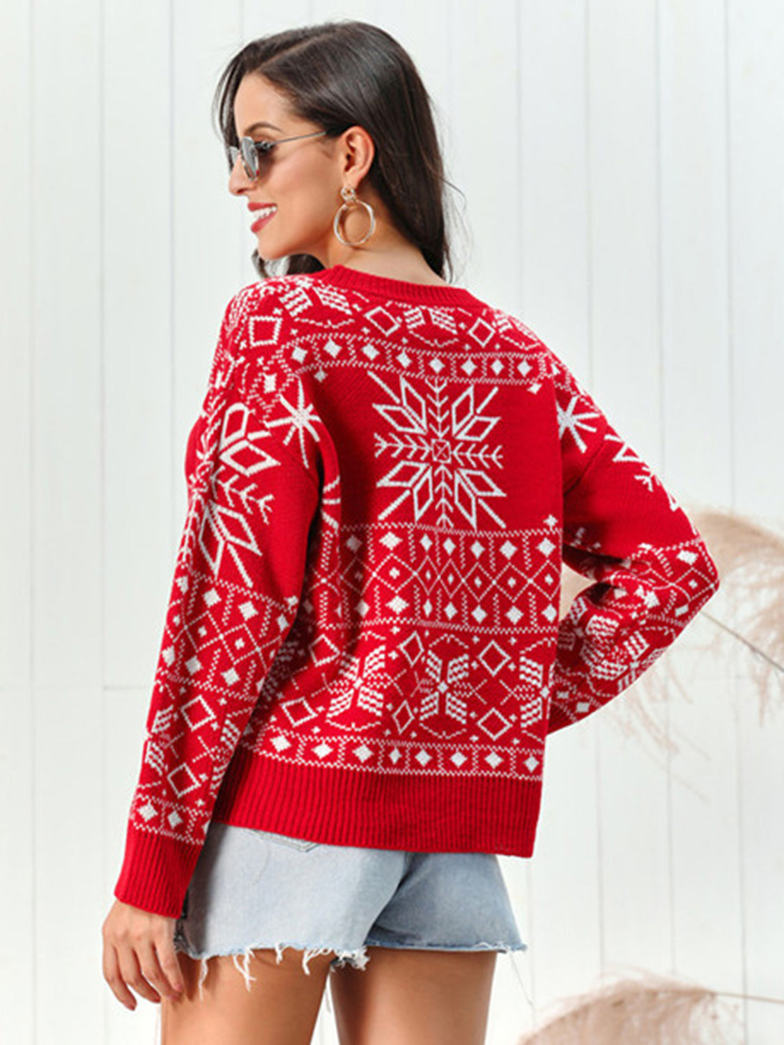 Red acrylic crewneck sweater with white snowflake and geometric pattern.