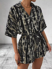 Black and cream tie-dye belted romper with collared neckline and button front.