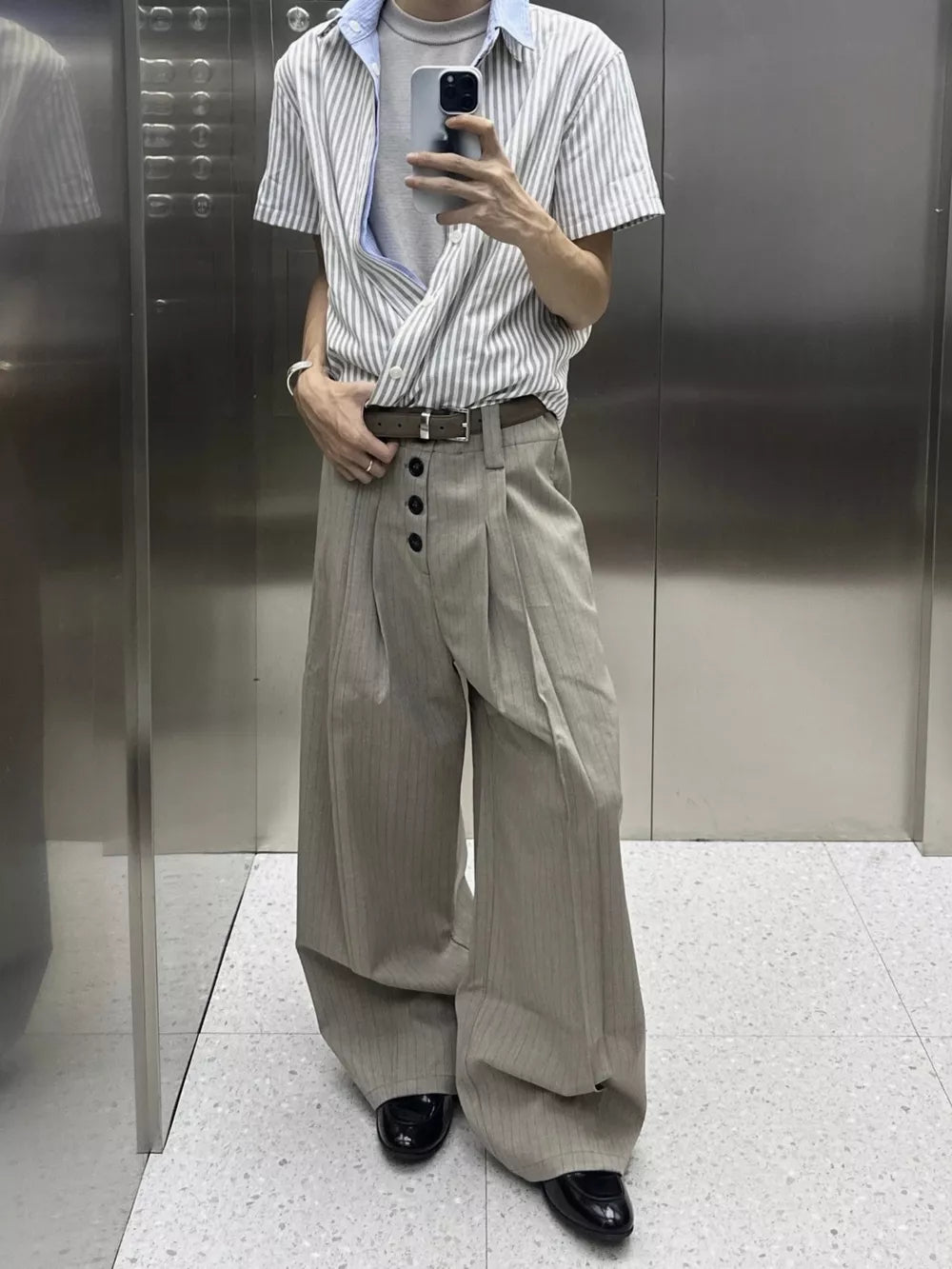 High-waisted wide-leg khaki pants with vertical pinstripes and a button fly.