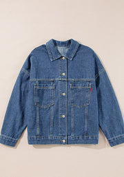 Oversized denim trucker jacket in blue with button closure and chest pockets.