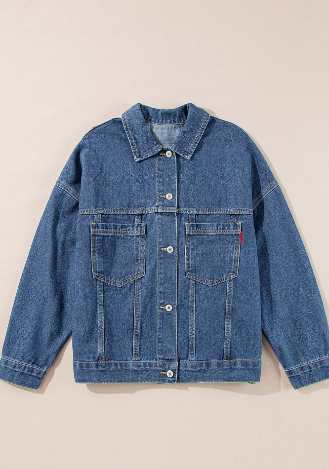 Oversized denim trucker jacket in blue with button closure and chest pockets.