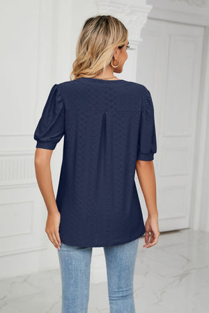Dark navy perforated puff sleeve blouse with keyhole detail and subtle pleating.