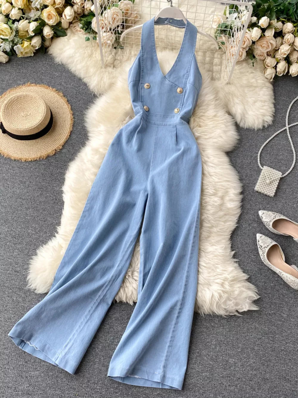 Light blue denim halter neck wide-leg jumpsuit with gold buttons.