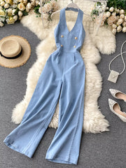 Light blue denim halter neck wide-leg jumpsuit with gold buttons.