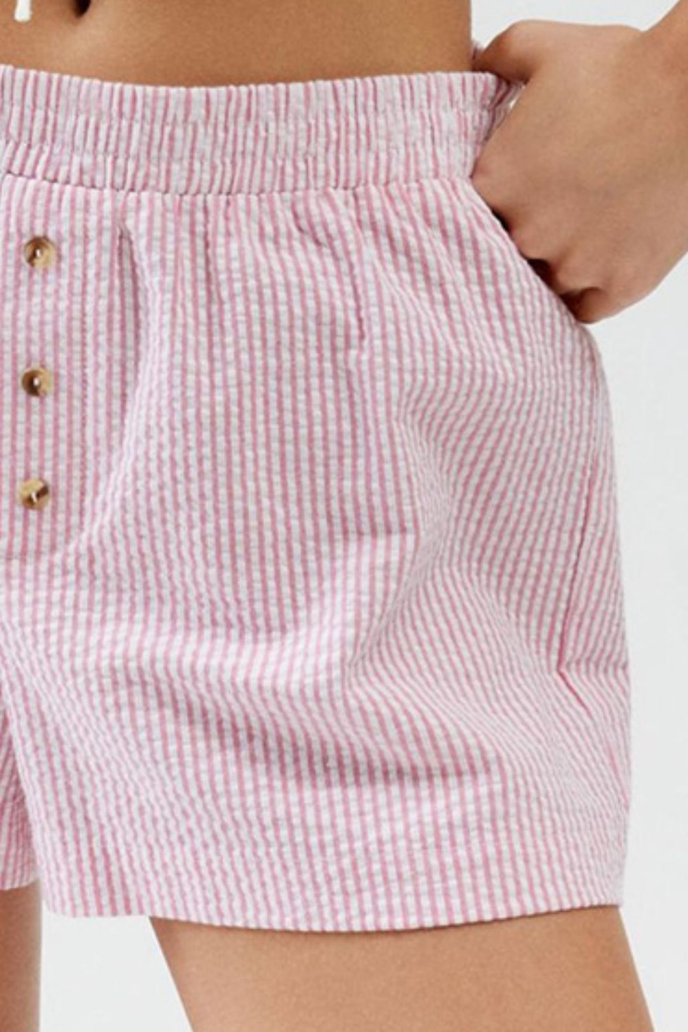 Pink seersucker boxer shorts with button detail and elastic waistband.