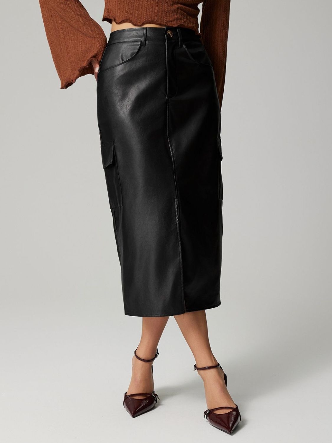 Black faux leather midi skirt with cargo pockets and buttoned front.