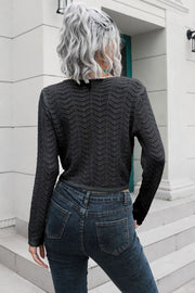 Black crochet knit cropped sweater with chevron pattern and long sleeves.