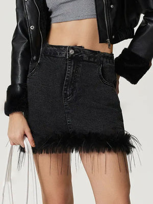 Black denim mini skirt with feather trim, buttoned front, and frayed hem.