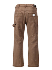 Taupe carpenter trousers with artisan paint splatter detail and utility pocket.