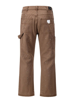 Taupe carpenter trousers with artisan paint splatter detail and utility pocket.