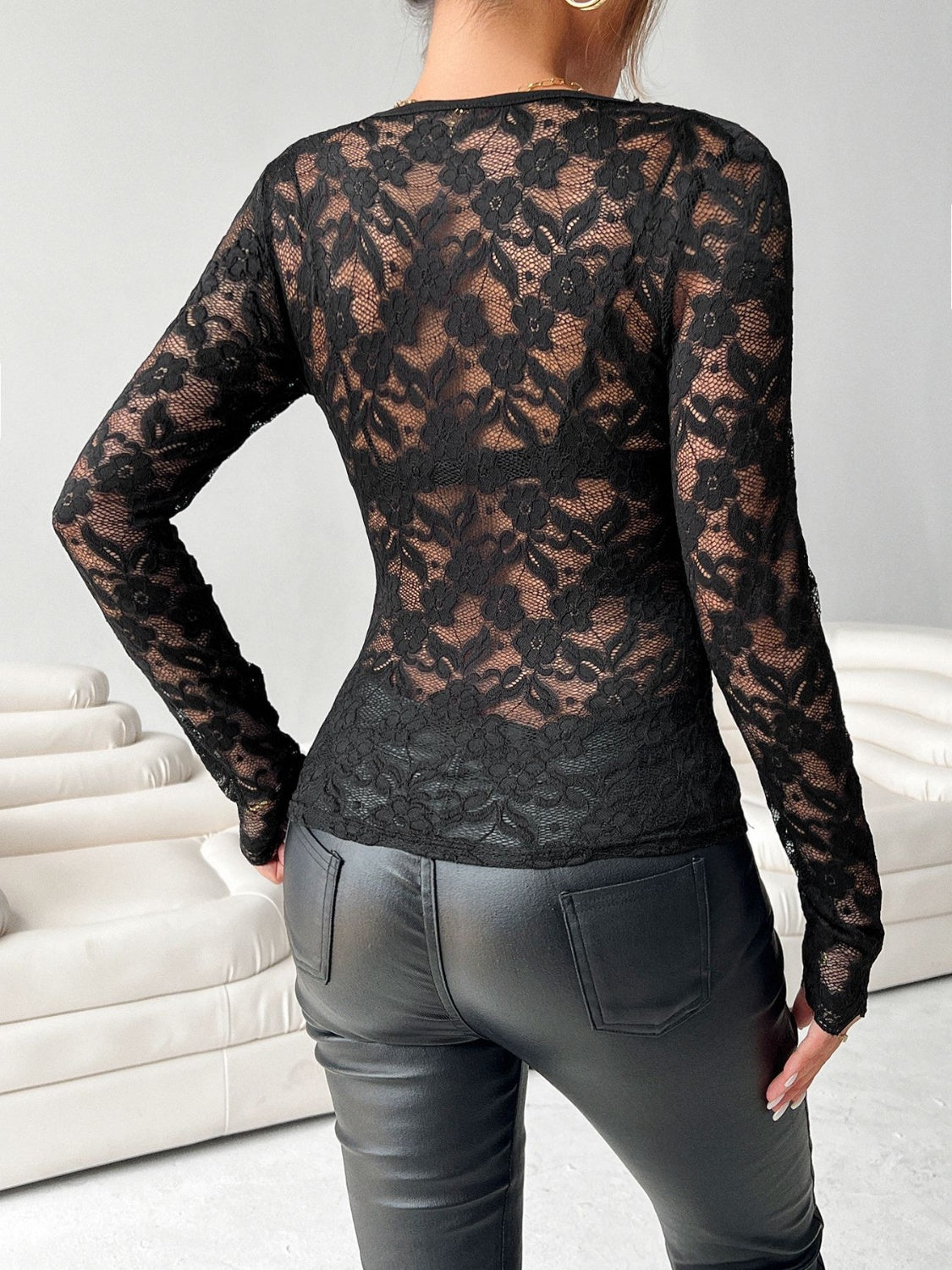 Black lace bodysuit with long sleeves and floral pattern.