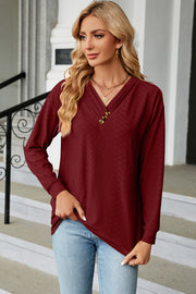 Burgundy textured henley v-neck top with three buttons and long sleeves.