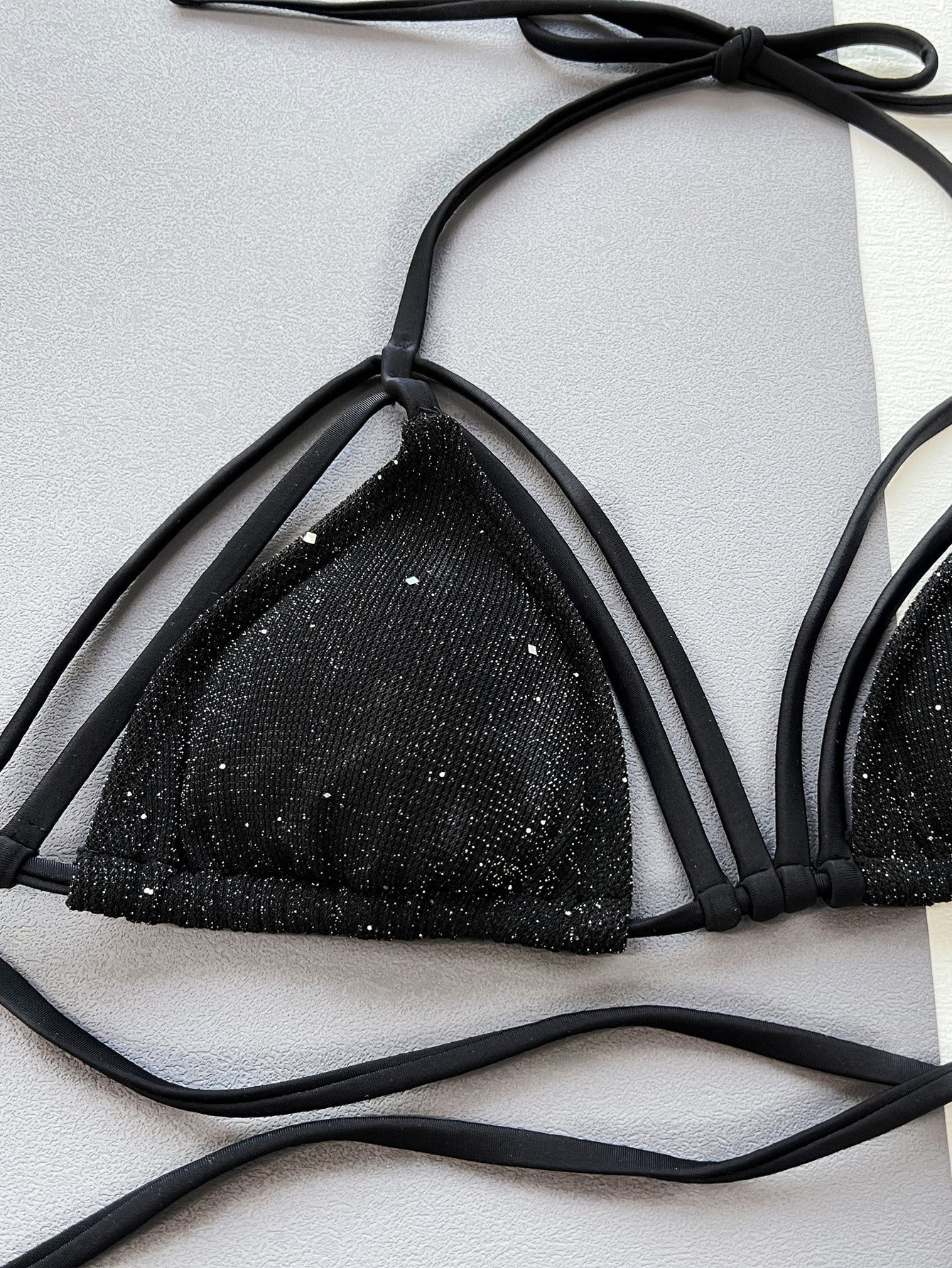 Black strappy bikini top with subtle sparkle detail and tie straps.