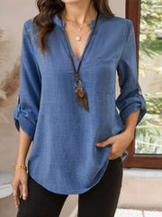 Blue textured casual shirt with notched V-neck, roll-tab sleeves, and curved hem.