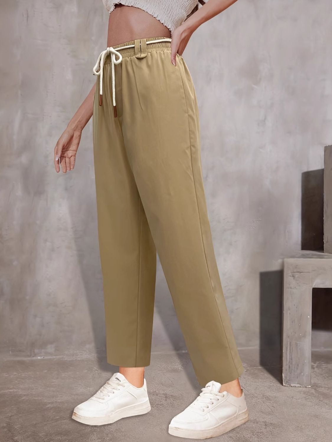 Khaki wide-leg trousers with drawstring waist and belt detail.