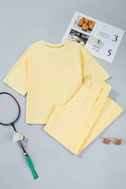Yellow cotton embroidered half-sleeve top and drawstring pants set with eyelet details.