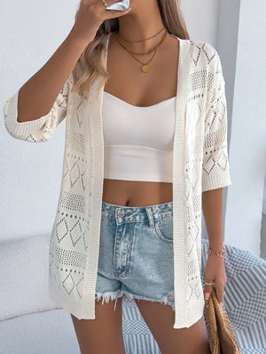 Cream openwork knit duster cardigan with elbow-length sleeves and diamond pattern.