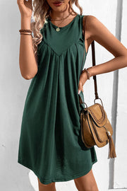 Forest green sleeveless trapeze dress with pleated yoke detail.
