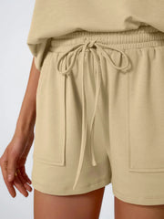 Tan drawstring shorts with elastic waist and patch pockets, part of a loungewear set.