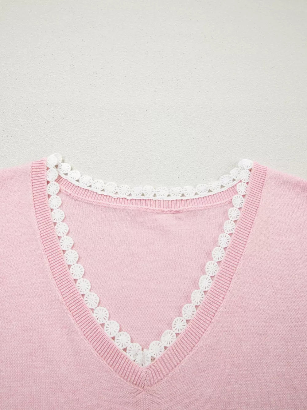 Pink knit v-neck top with white lace trim detail