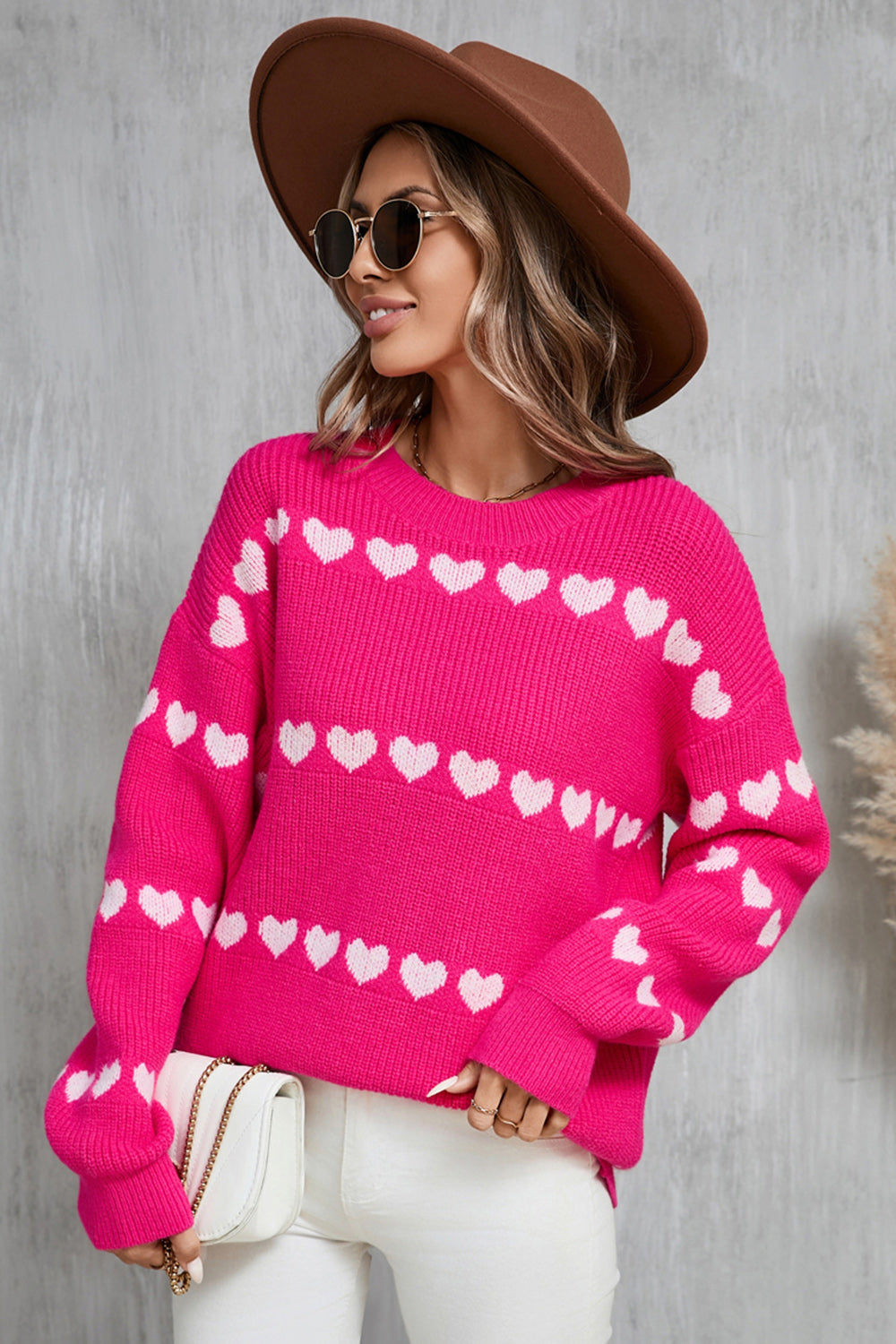 Hot pink knit pullover sweater with white heart pattern, crew neck, long sleeves.