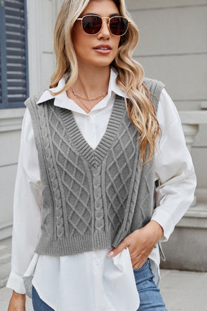 Gray cable knit diamond pattern sweater vest with V-neck, styled over a white collared shirt.