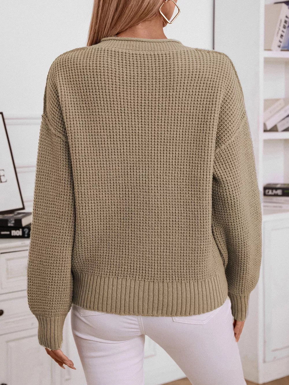 Relaxed knit sweater in olive green with waffle texture and button detail.