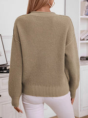 Relaxed knit sweater in olive green with waffle texture and button detail.