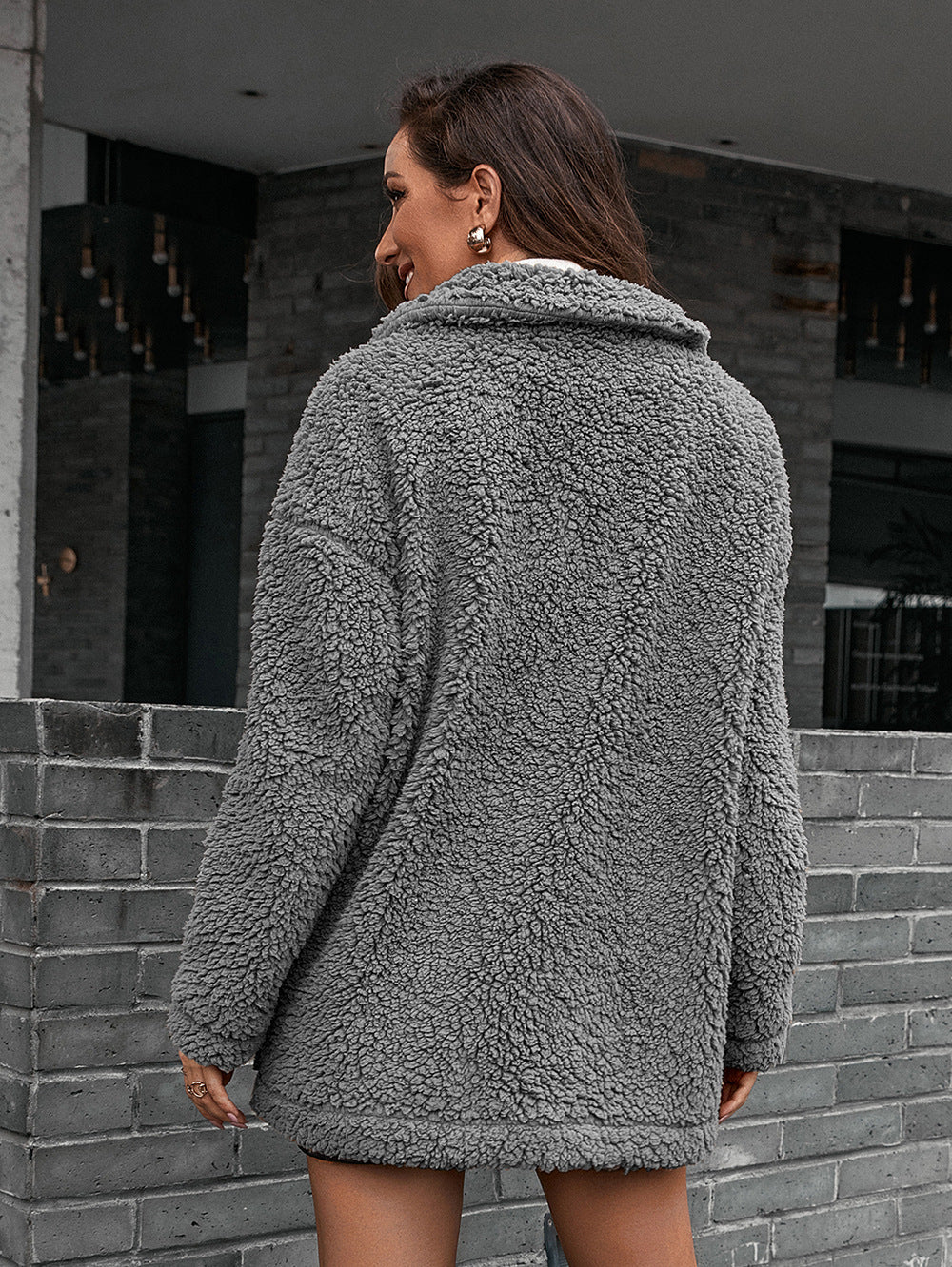 Gray teddy moto jacket with collared neckline and asymmetrical detail.