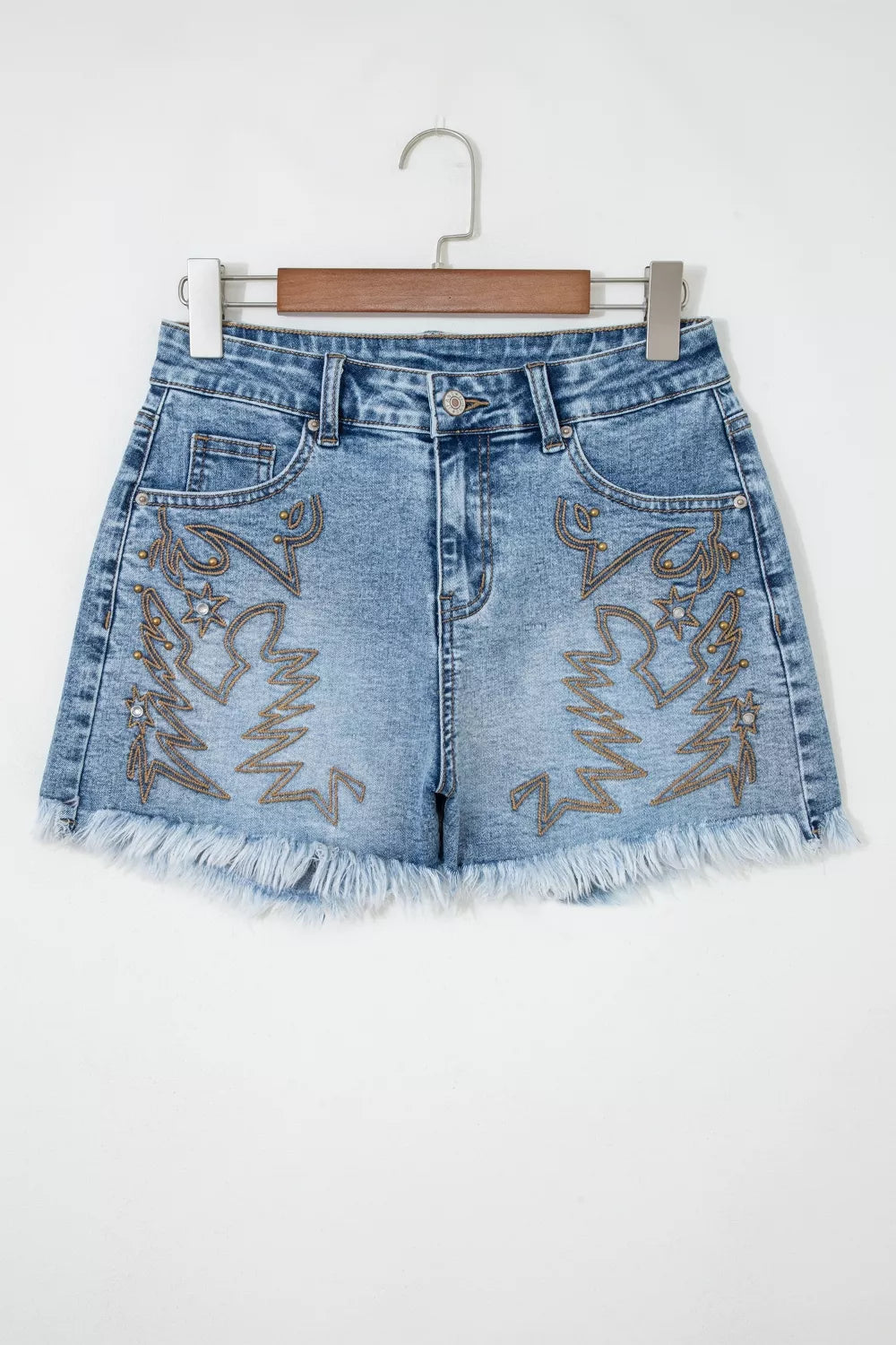 Embroidered denim shorts with distressed frayed hem and western boot design.