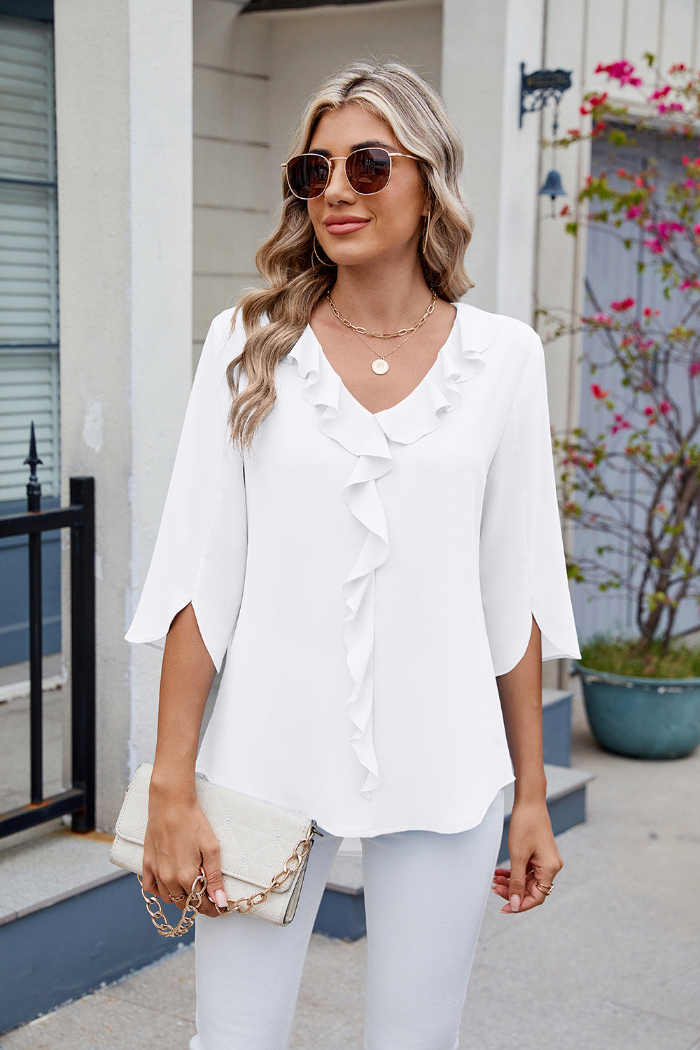 White V-neck flutter sleeve blouse with ruffled front detail.