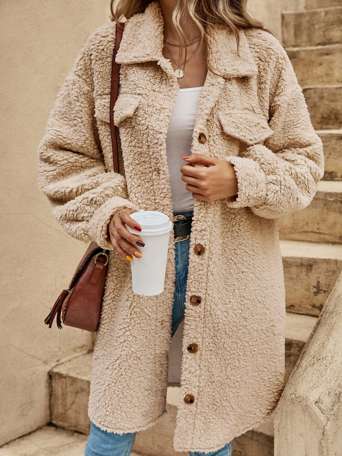 Oversized teddy bear shacket in tan with button-down front and chest pockets.