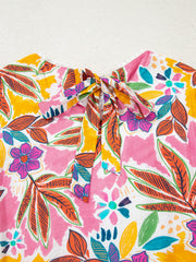 Print bell sleeve mini dress with a colorful floral pattern and tie-neck detail.