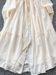 Off-white textured tiered long sleeve midi dress with button-down front and tie waist.
