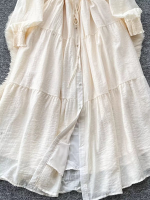 Off-white textured tiered long sleeve midi dress with button-down front and tie waist.