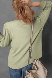 Sage textured blouse with puff sleeves and elastic cuffs.