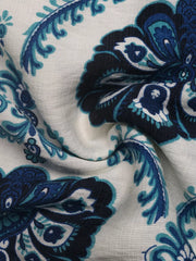 Elegant maxi dress fabric detail with blue paisley print on white.