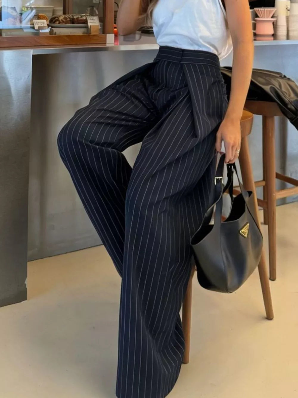 Wide-leg pants in dark blue with white pinstripes, featuring a high waist and flowing silhouette.