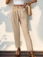 Tan linen blend trousers with gathered waistline, button detail, and side pockets.